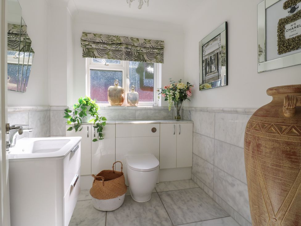 A bathroom featuring a toilet, sink, and decorative items at Panel Place near Pett