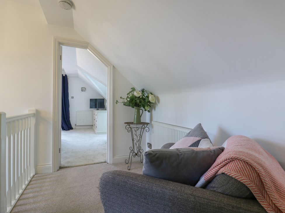 A landing with a sofa and a view of a doorway at Panel Place near Pett