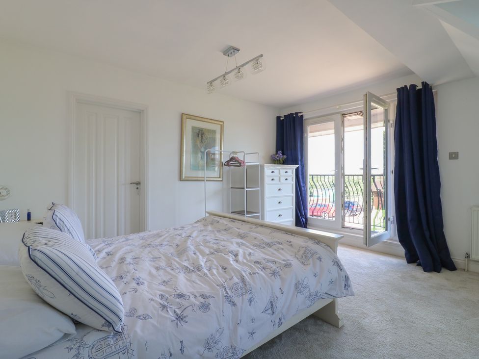 A bedroom with a bed and wardrobe at Panel Place near Pett