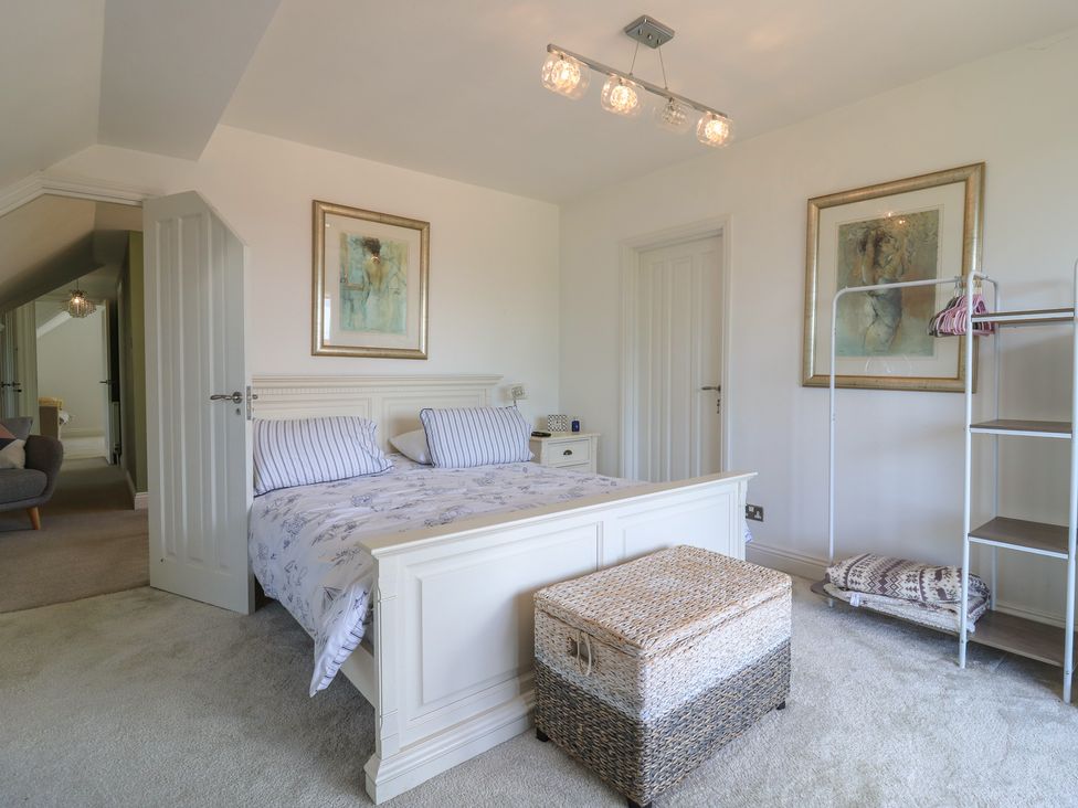 A bedroom with a bed and clothing rack at Panel Place near Pett