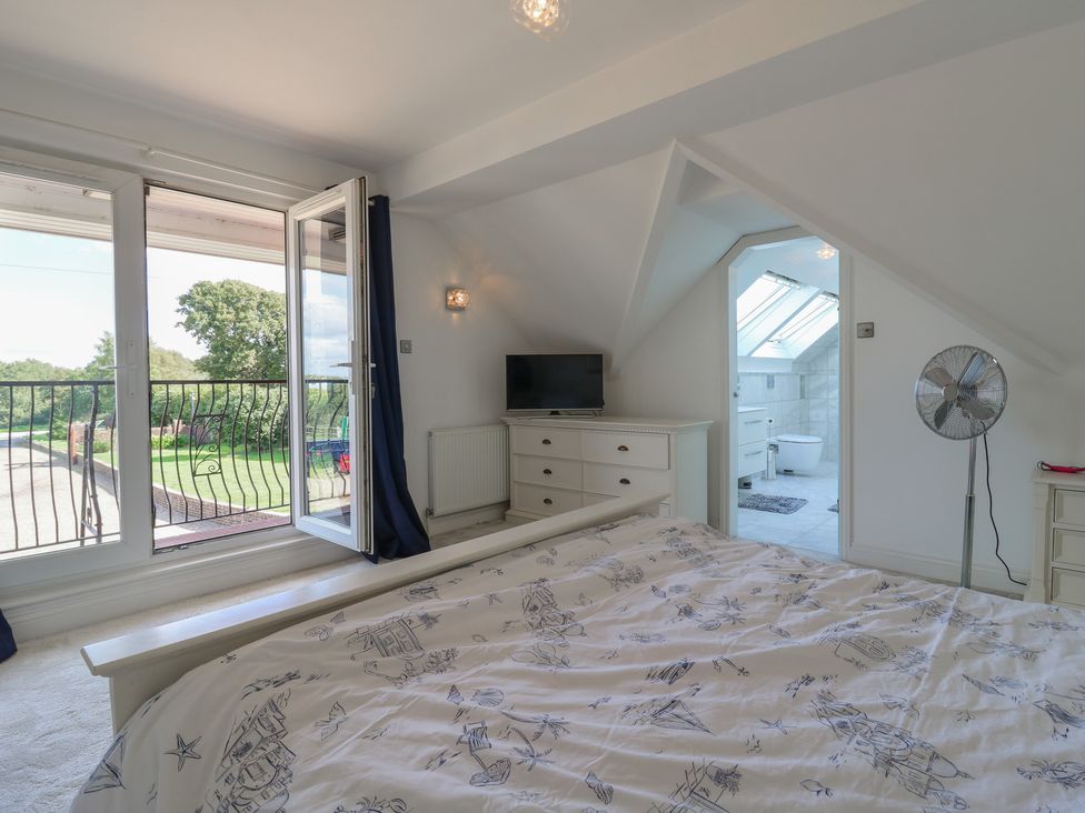 A bedroom with a bed and television at Panel Place near Pett