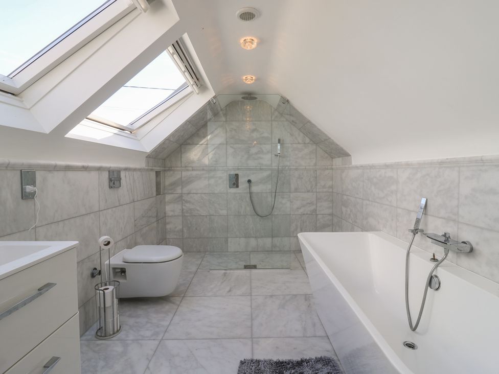 A bathroom with a bath tub and toilet at Panel Place near Pett