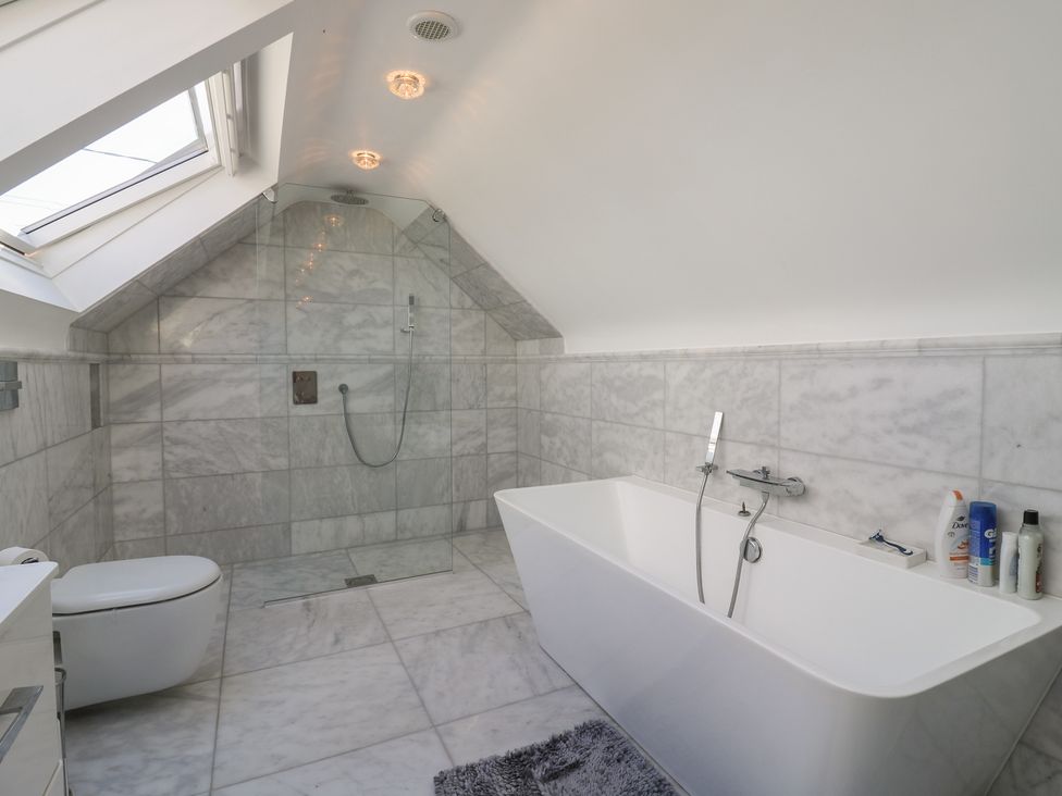 A bathroom with a bathtub and a shower at Panel Place near Pett