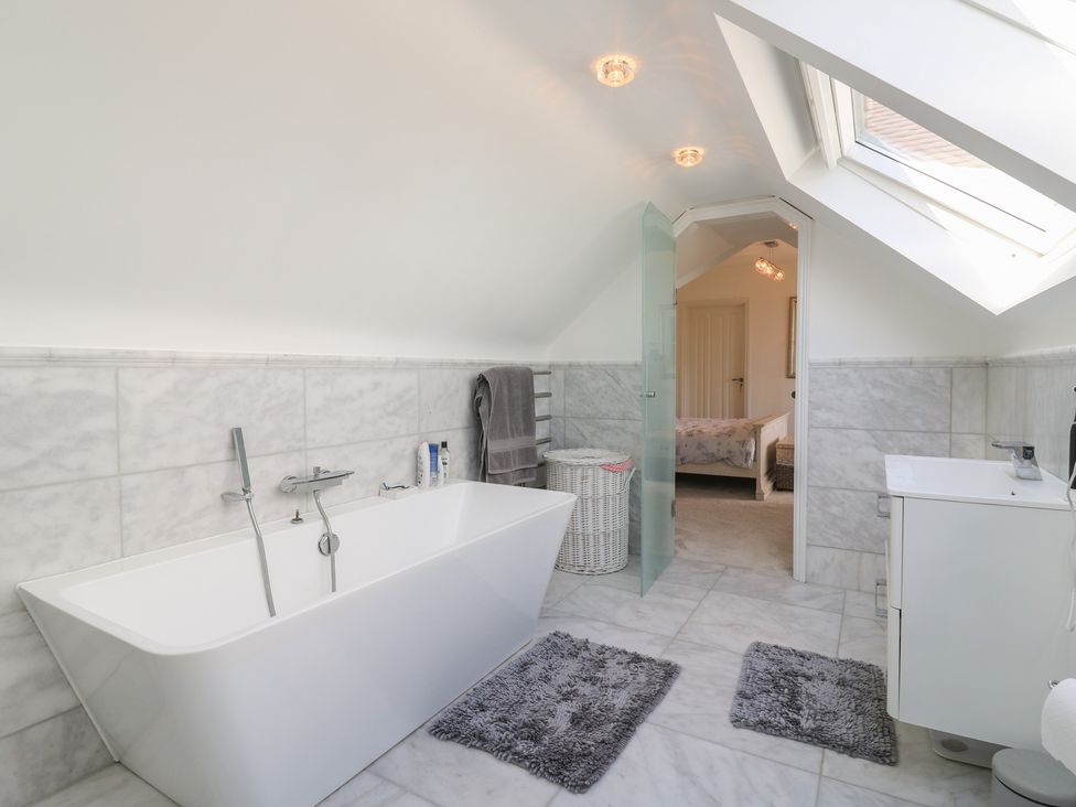 A bathroom with a bathtub and sink at Panel Place near Pett
