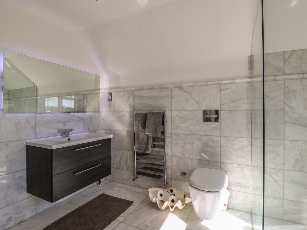A bathroom with a sink, toilet, and towel rack at Panel Place near Pett