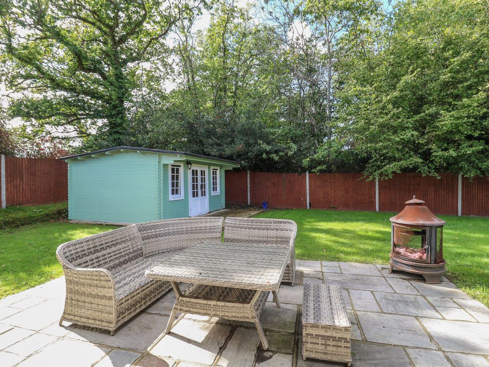A garden with outdoor seating and a shed at Panel Place near Pett