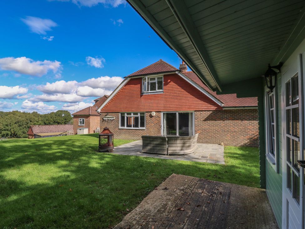 An outdoor view of a house with a garden and patio at Panel Place near Pett