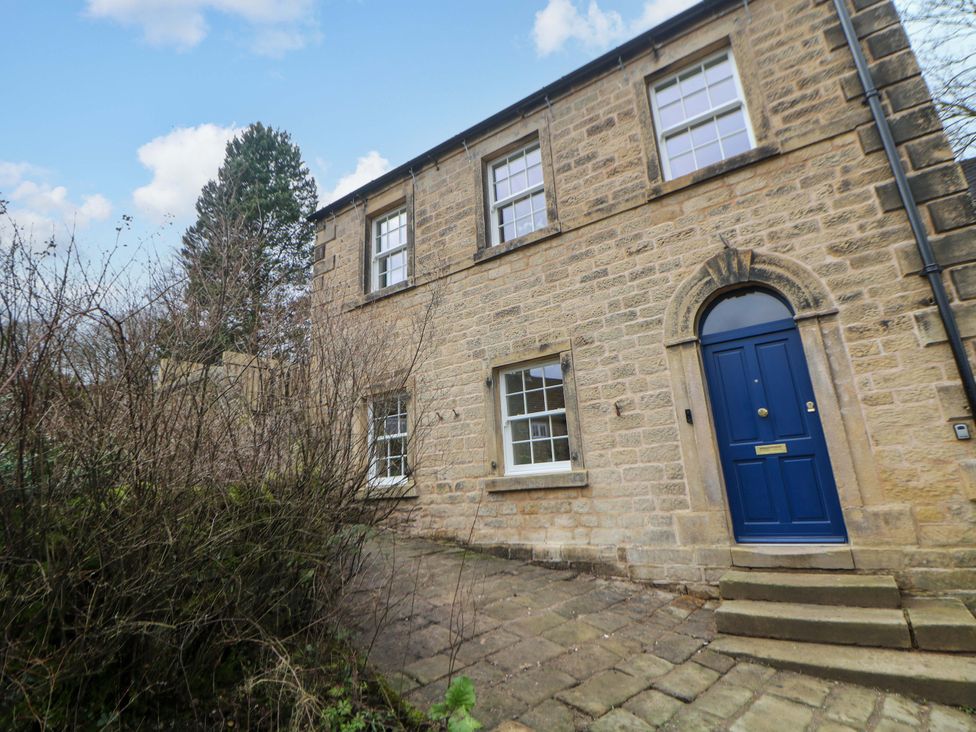 A house with a blue door and stone wall at The Reading Room in Hope Valley
