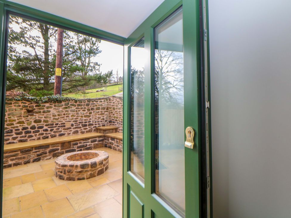 An outdoor area with a fire pit and stone wall at The Reading Room in Hope Valley