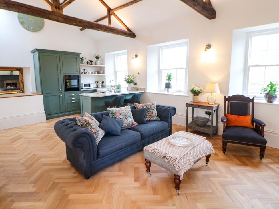 A living room with a sofa and kitchen area at The Reading Room Hope Valley