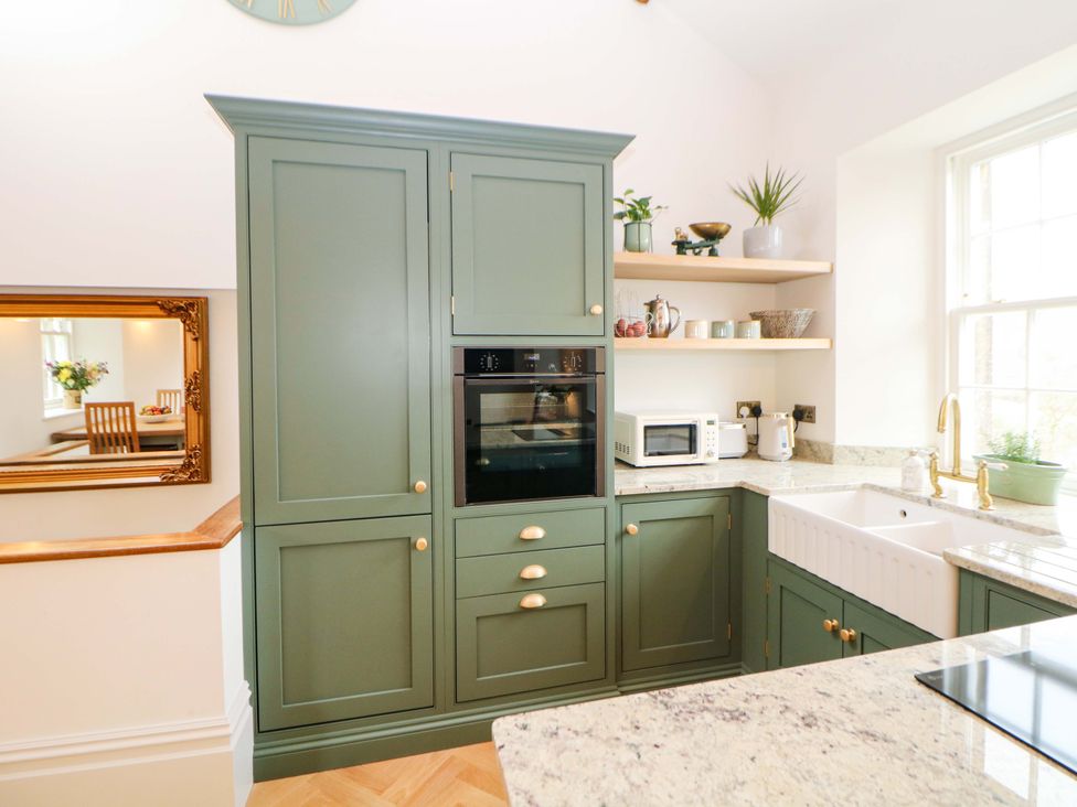 A kitchen with cabinets and appliances at The Reading Room in Hope Valley
