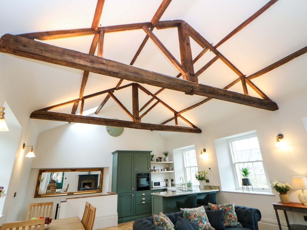 A living room with a dining table and kitchen cabinet at The Reading Room in Hope Valley