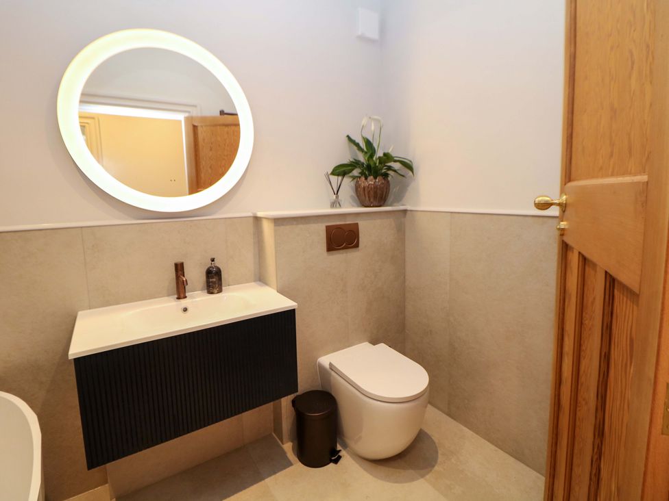 A bathroom with a sink, toilet and mirror at The Reading Room in Hope Valley