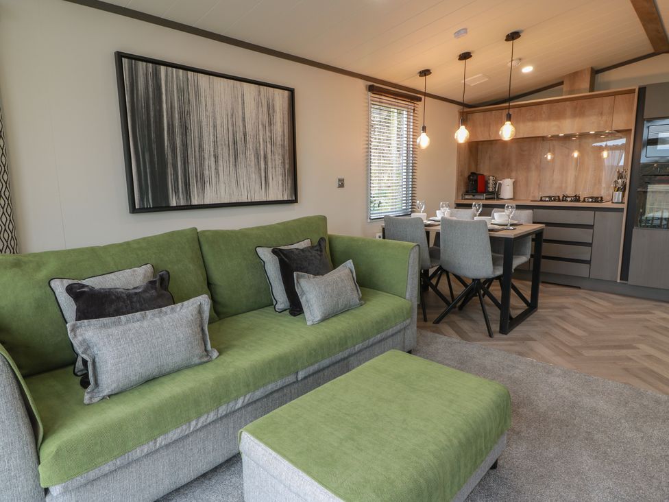 A living room with a sofa and dining area at Willow's Way in Stranraer