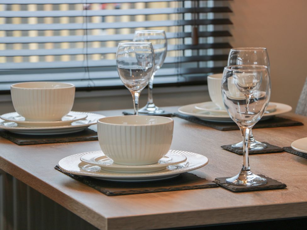 A dining table set with plates and glasses at Willow's Way in Stranraer