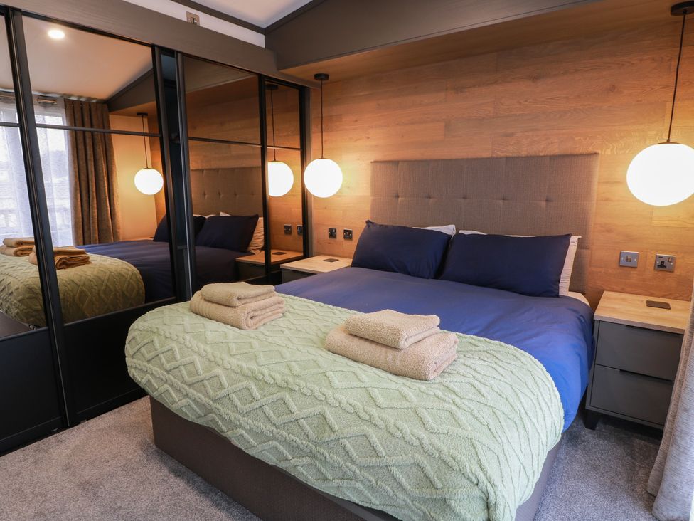 A bedroom with a bed and mirrored wardrobe at Willow's Way in Stranraer