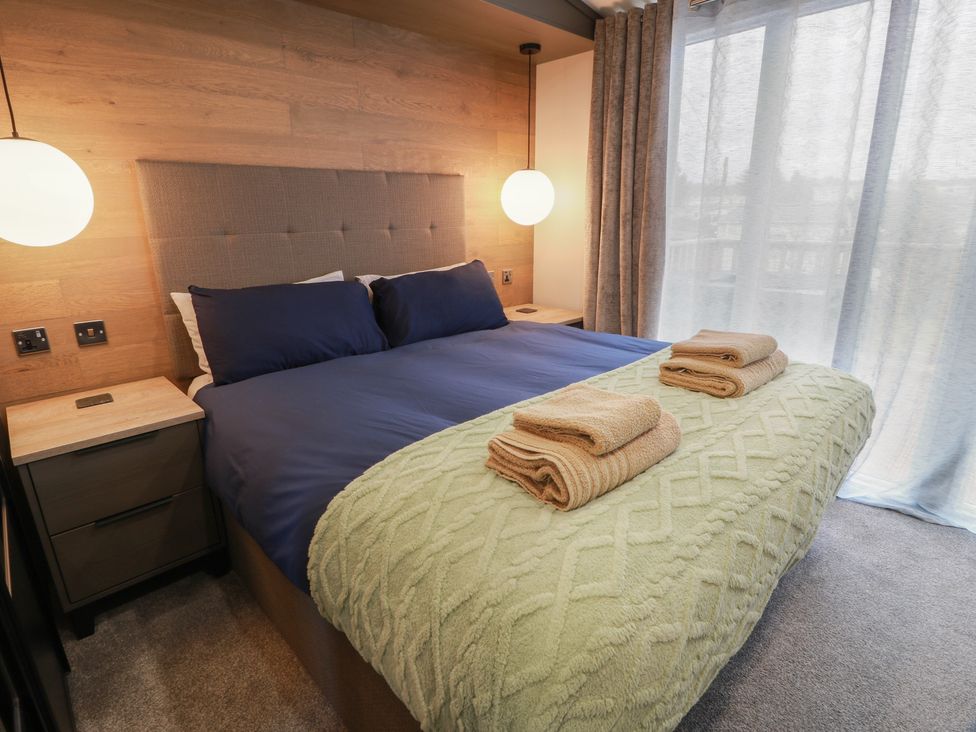 A bedroom with a bed and towels at Willow's Way in Stranraer