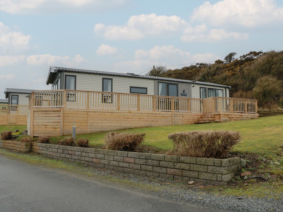 A holiday home with a wooden deck and fencing at Willow's Way in Stranraer