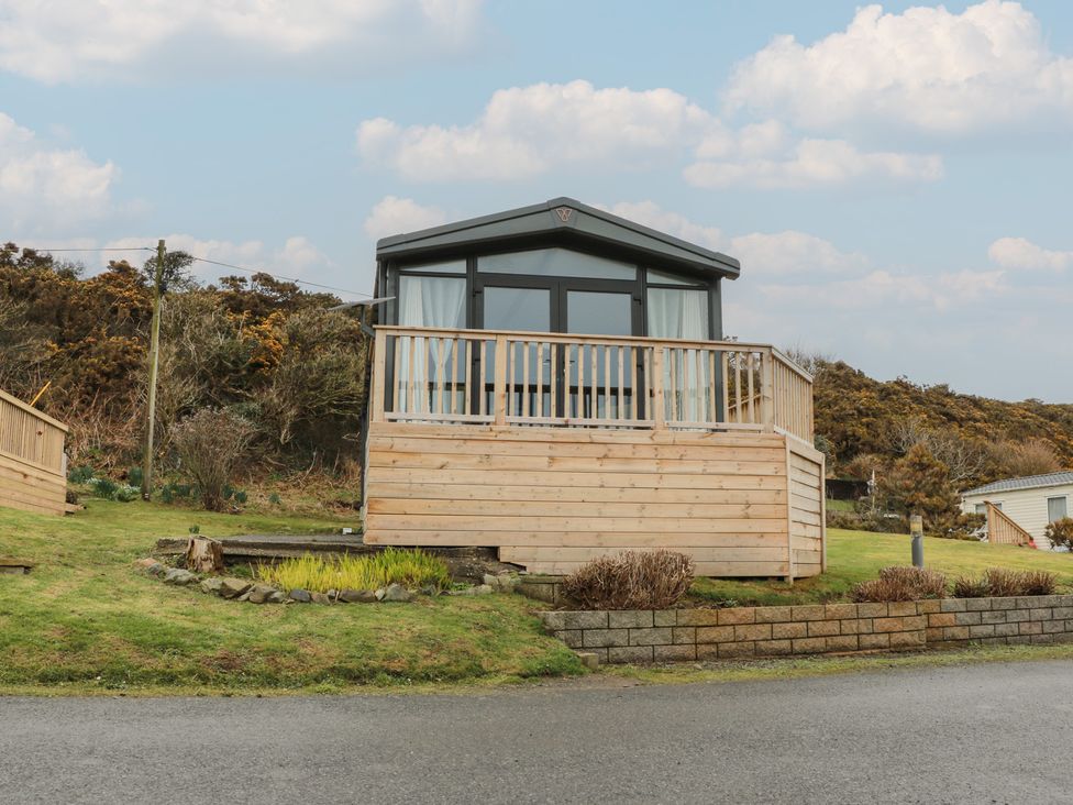 A cabin with decking and railing at Willow's Way in Stranraer