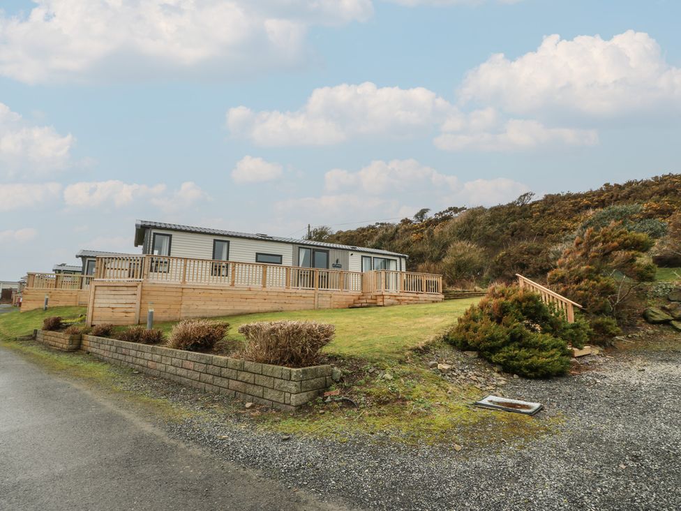 An outdoor area featuring a mobile home with a deck and grass at Willow's Way in Stranraer