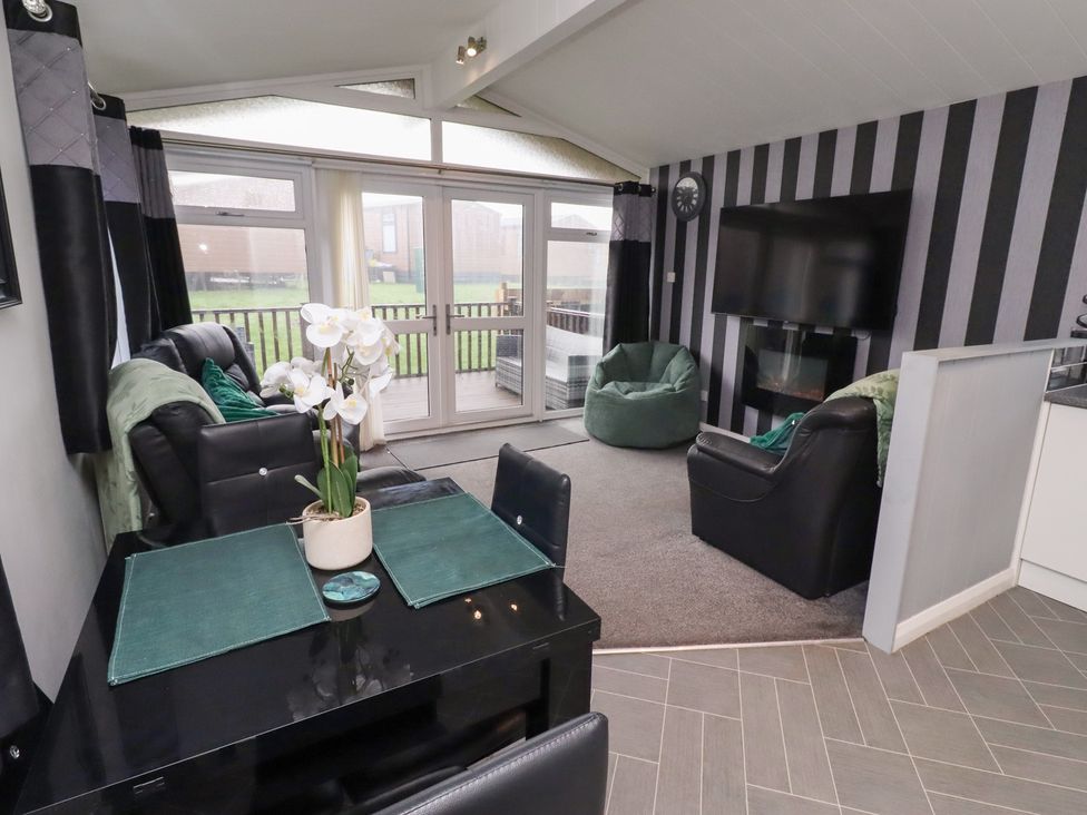 A living room with a sofa and dining table at Harper's Hideaway near Felmoor Holiday Park near Felton