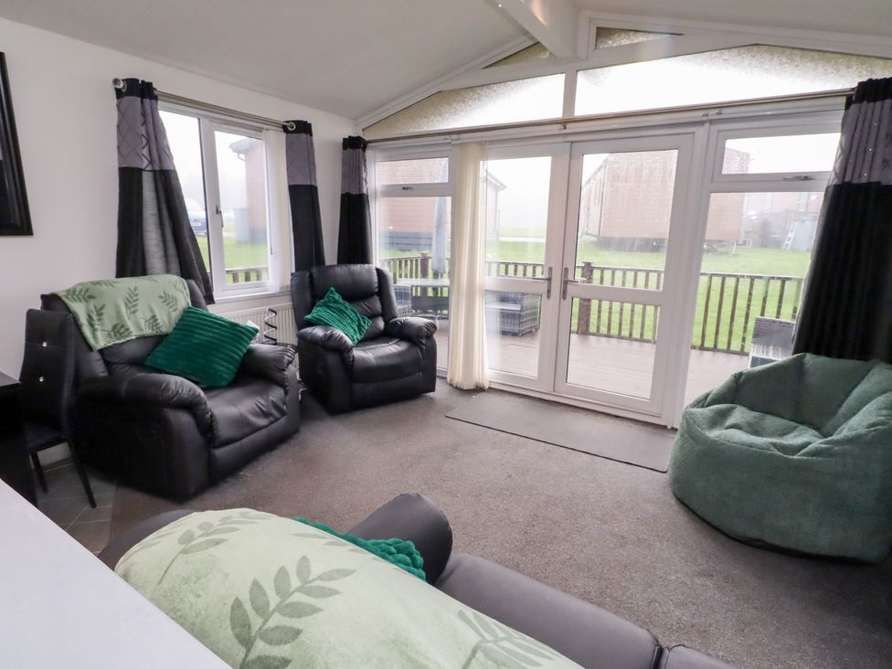 A living room with sofas and bean bags at Harper's Hideaway near Felmoor Holiday Park near Felton