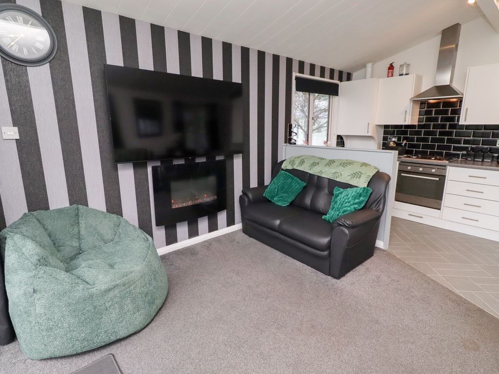 A living room with a television and electric fireplace at Harper's Hideaway near Felmoor Holiday Park near Felton