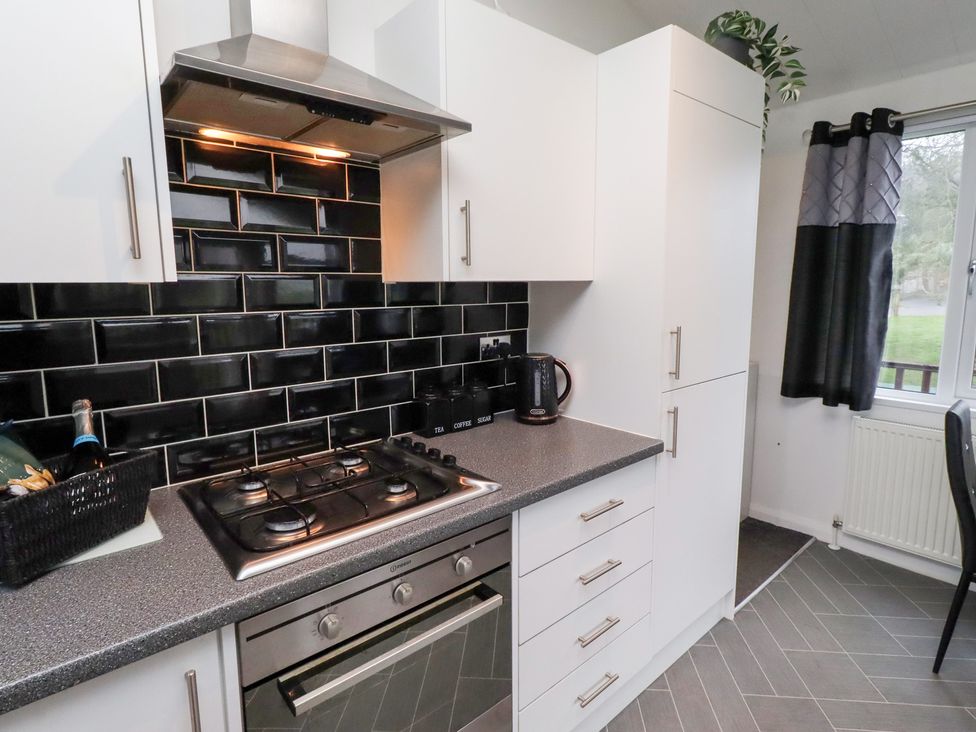 A kitchen with a stove and extractor fan at Harper's Hideaway near Felmoor Holiday Park near Felton