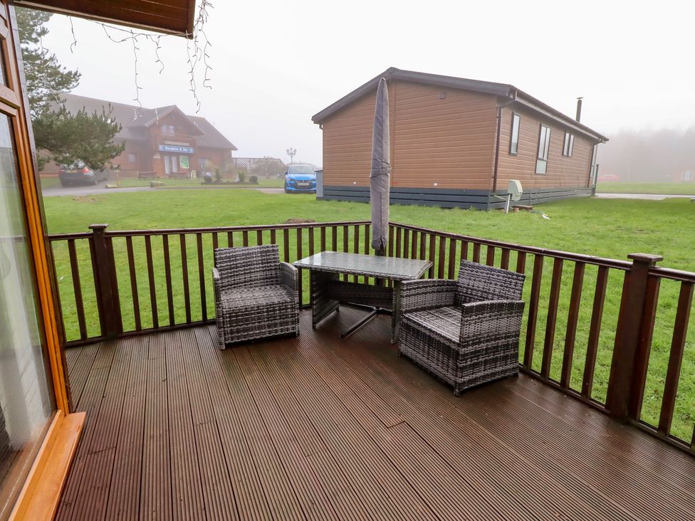 An outdoor seating area with a table and chairs at Harper's Hideaway near Felmoor Holiday Park