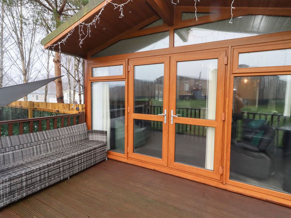 An outdoor area with wooden doors and seating at Harper's Hideaway near Felmoor Holiday Park near Felton