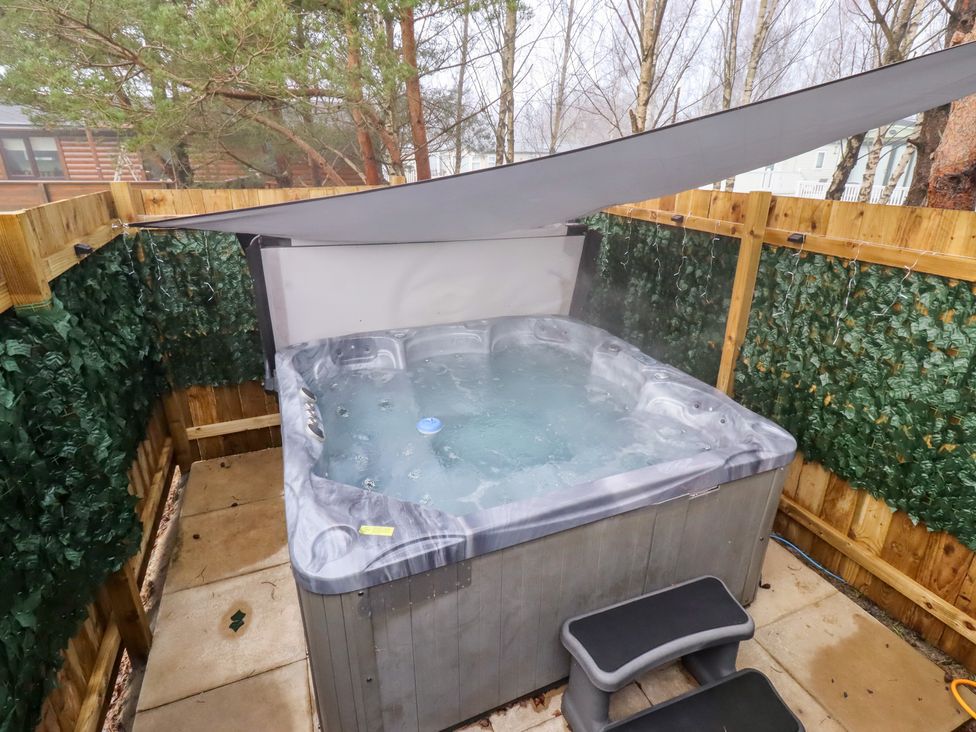 A hot tub with steam and steps at Harper's Hideaway near Felmoor Holiday Park