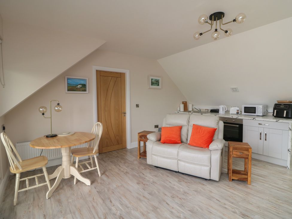 A living room with a sofa and dining table at Ard Uisce @ Estuary Bliss, Duncannon, County Wexford