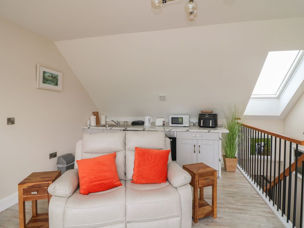 A living room with a sofa and kitchenette at Ard Uisce @ Estuary Bliss, Duncannon, County Wexford