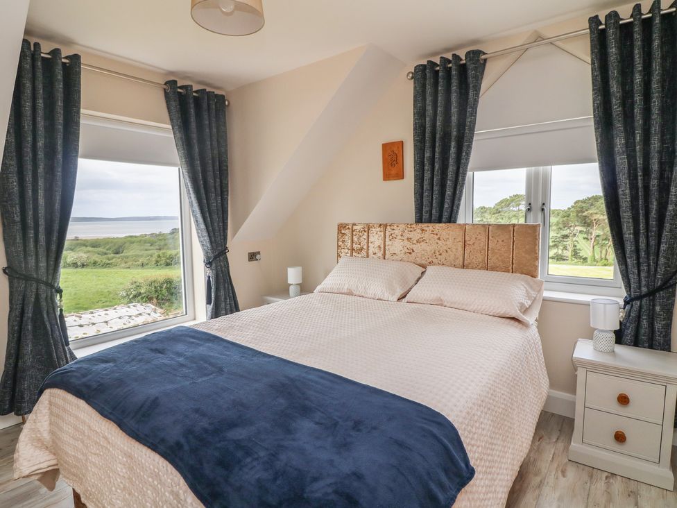 A bedroom with a bed and window at Ard Uisce @ Estuary Bliss, Duncannon, County Wexford
