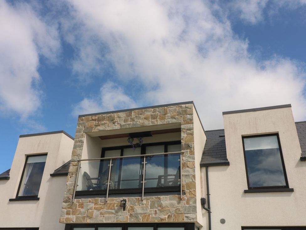 A balcony with stone facade and large windows at Ard Uisce @ Estuary Bliss, Duncannon, County Wexford