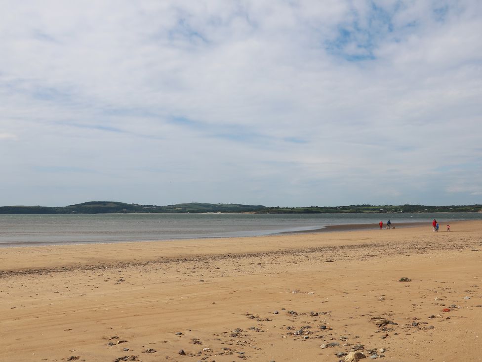 A beach with people walking along the shore at Ard Uisce @ Estuary Bliss Duncannon, County Wexford