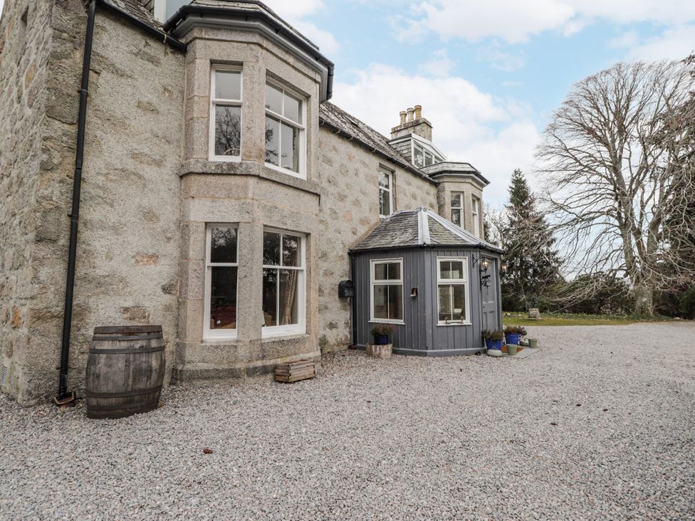 An outdoor view of a stone building with windows and a round extension at Achnagonlin House in Grantown-on-Spey