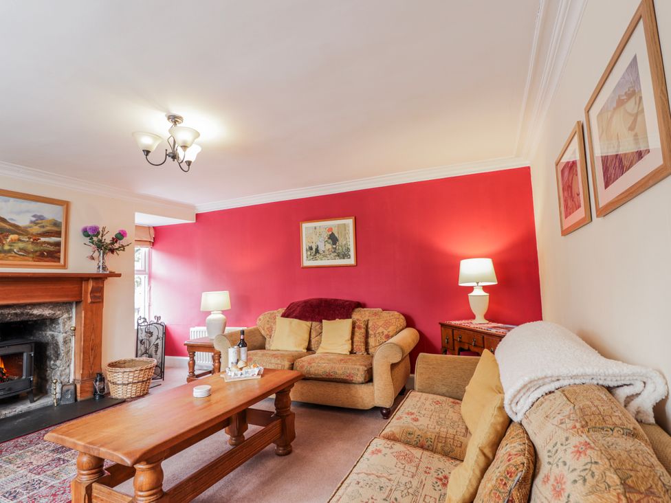 A living room with a fireplace and two sofas at Achnagonlin House in Grantown-on-Spey