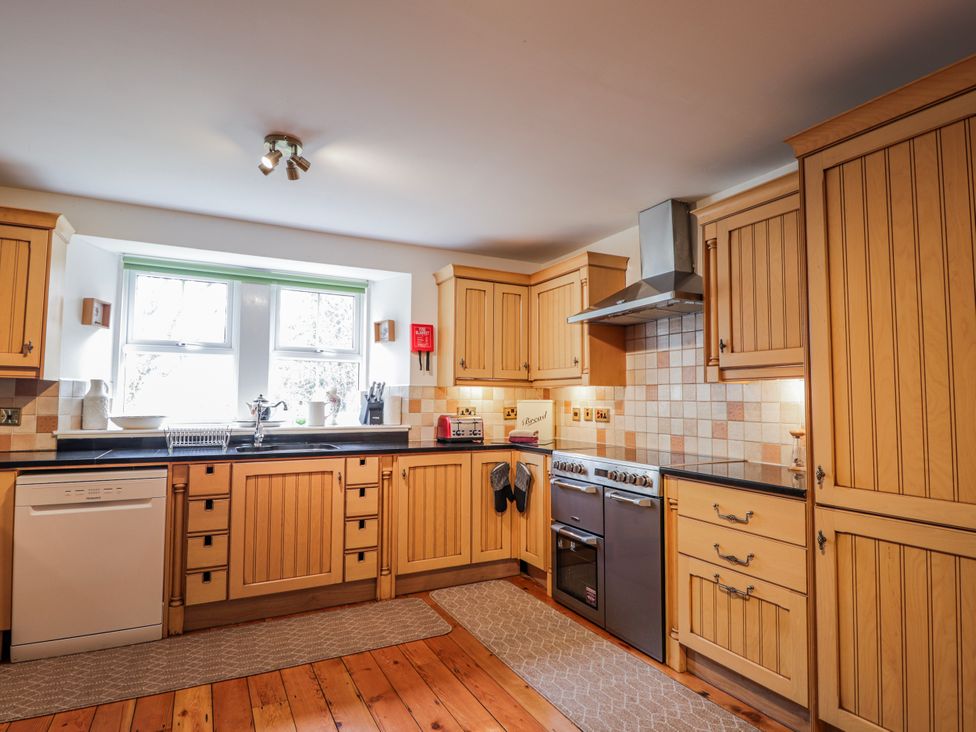 A kitchen with wooden cabinets and appliances at Achnagonlin House in Grantown-on-Spey