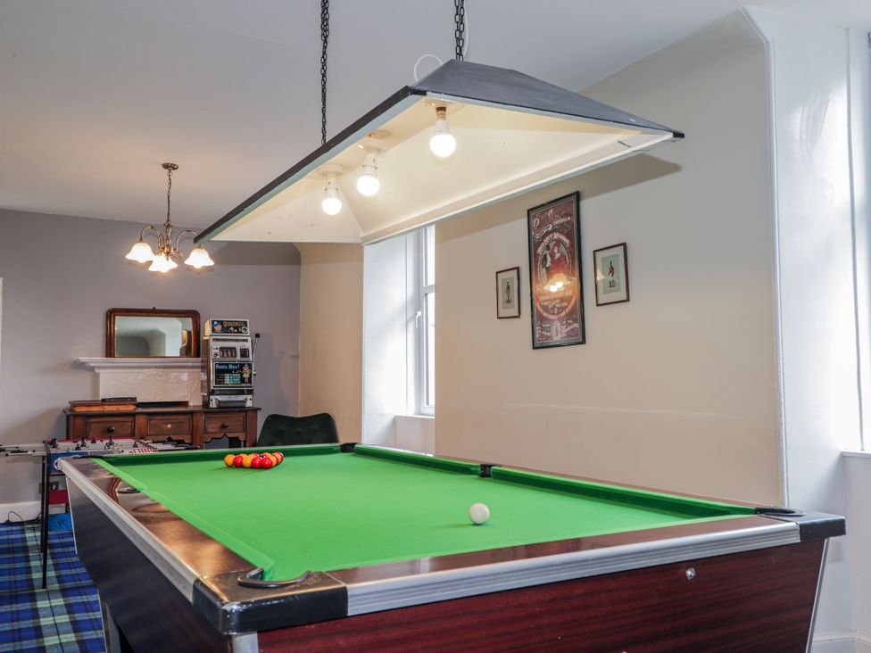 A game room with a pool table and light fixture at Achnagonlin House in Grantown-on-Spey