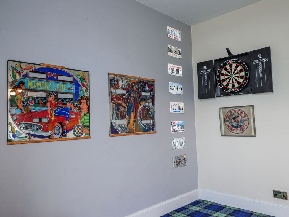 A recreation room with a dartboard and framed art at Achnagonlin House in Grantown-on-Spey