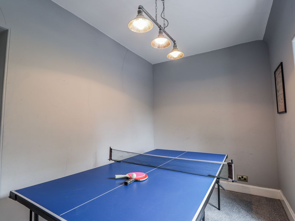 A ping pong table with a paddle in a games room at Achnagonlin House in Grantown-on-Spey