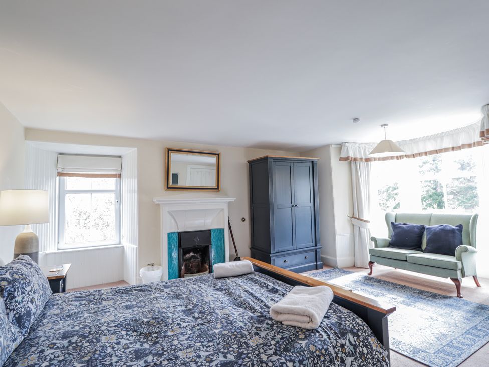 A bedroom with a bed and wardrobe at Achnagonlin House in Grantown-on-Spey
