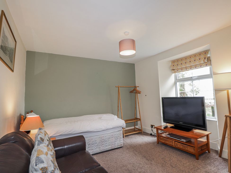A living room with a bed and television at Achnagonlin House in Grantown-on-Spey