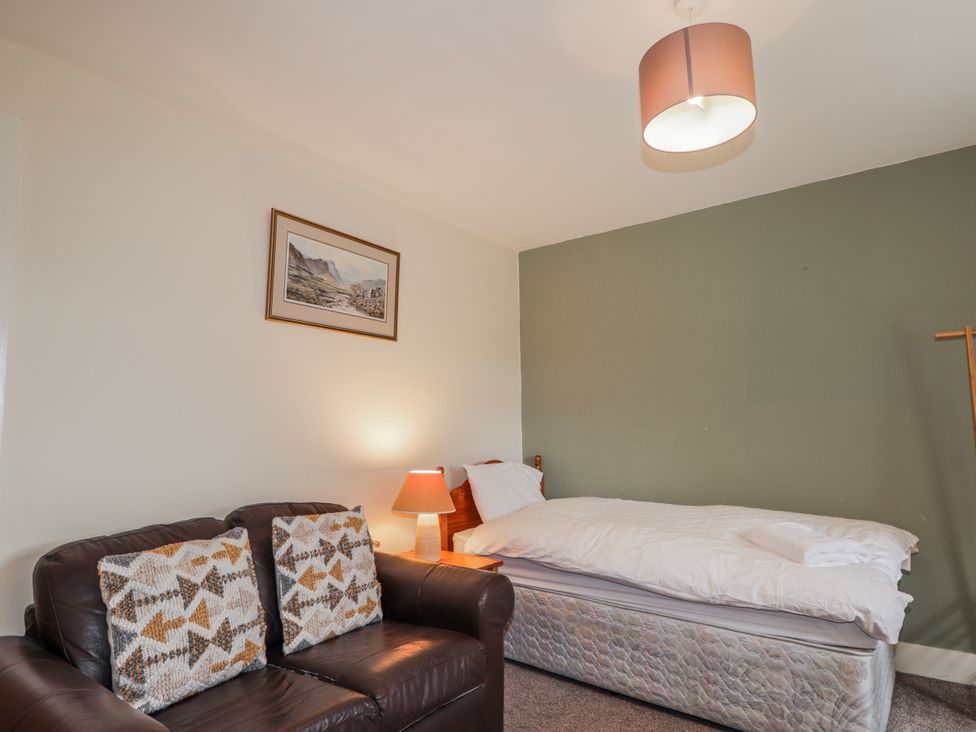 A bedroom with a bed and sofa at Achnagonlin House in Grantown-on-Spey