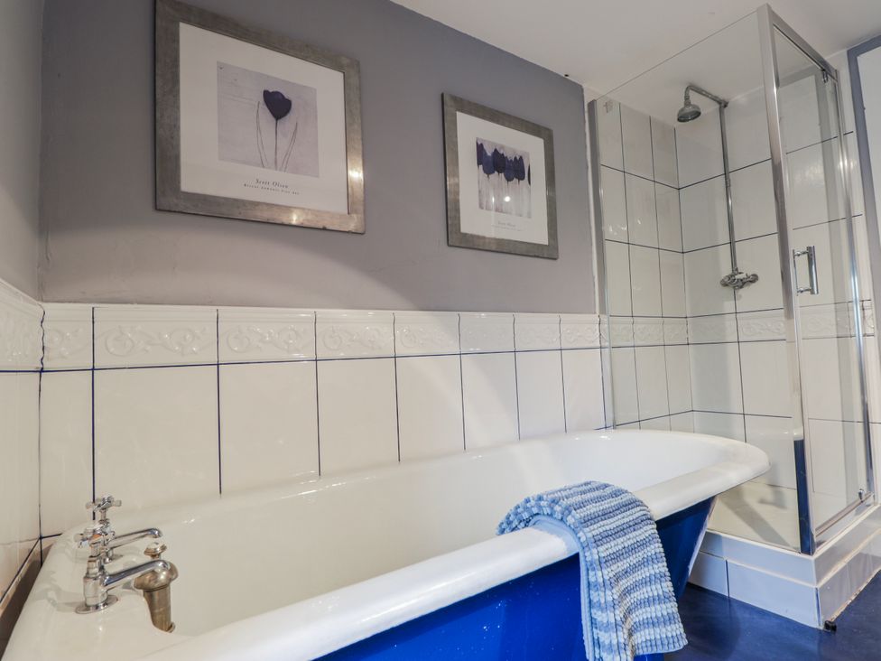 A bathroom with a bathtub and shower area at Achnagonlin House in Grantown-on-Spey