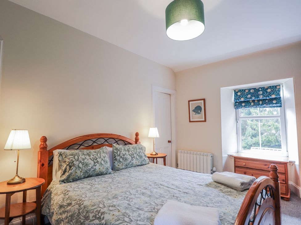 A bedroom with a double bed and a dressing table at Achnagonlin House in Grantown-on-Spey