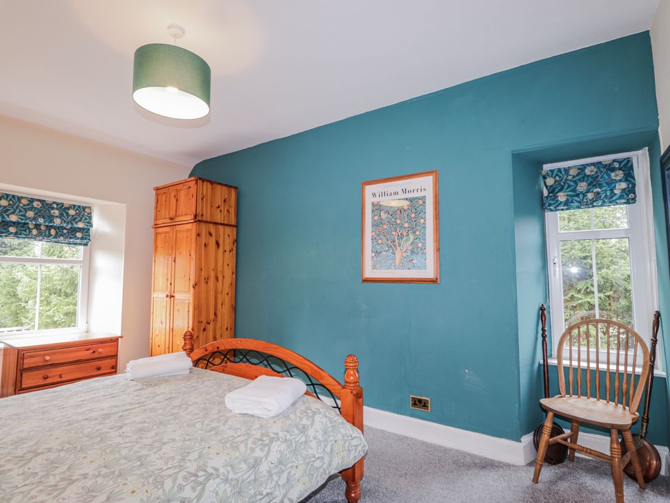 A bedroom with a bed and wardrobe at Achnagonlin House in Grantown-on-Spey