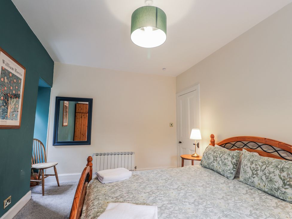 A bedroom with a bed and side table at Achnagonlin House, Grantown-on-Spey