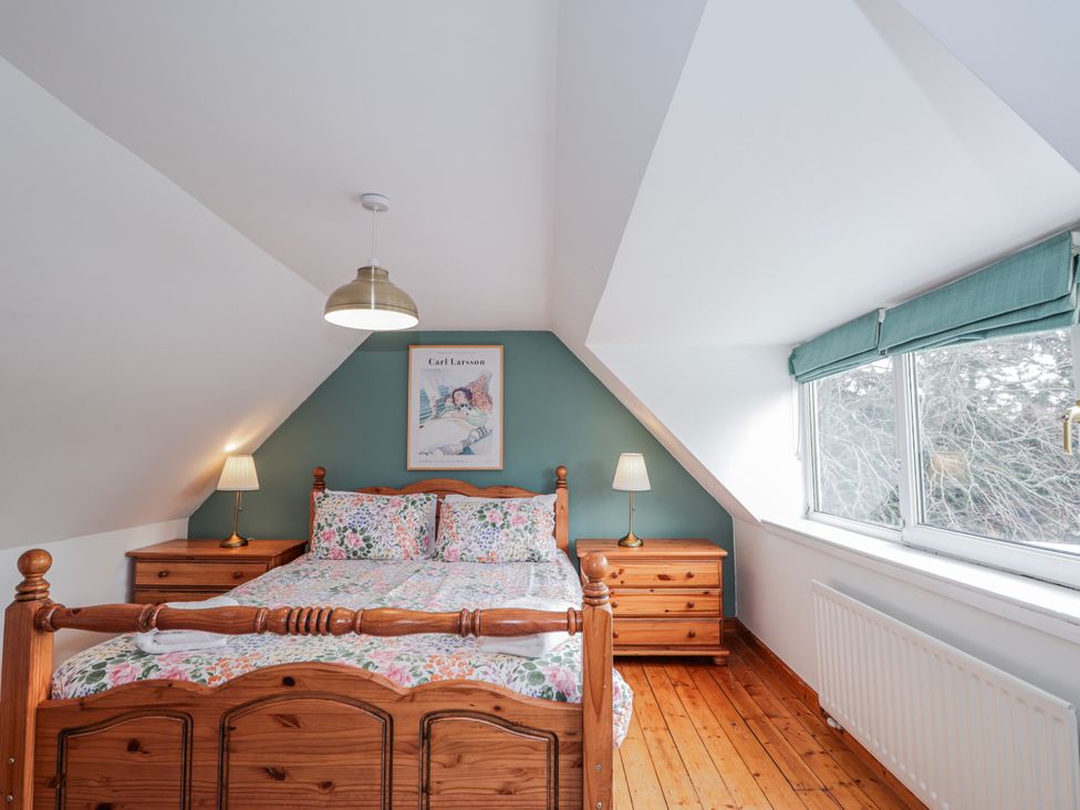 A bedroom with a bed and nightstand at Achnagonlin House in Grantown-on-Spey